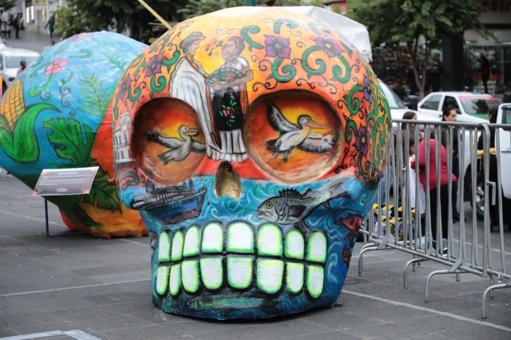 Montan cráneos gigantes de papel y cartón de varias regiones del estado, en Plaza&nbsp;Lerdo.